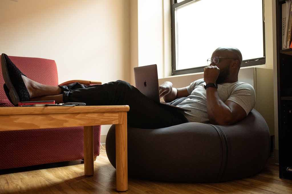 Person sitting on a bean bag chair with a laptop writing a blog